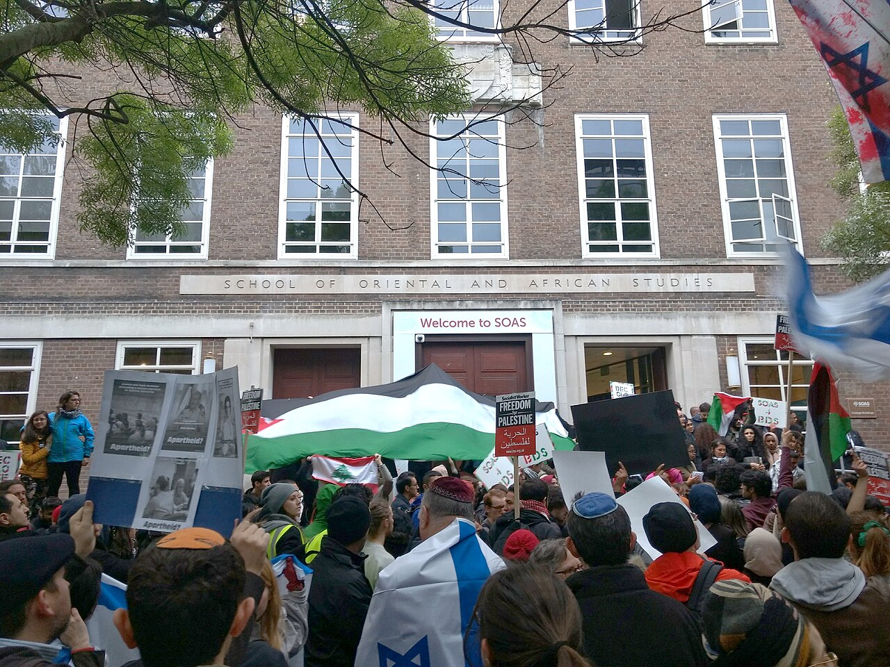 Demonstrasi BDS, dengan pengunjuk rasa anti-BDS yang lebih dekat dengan kamera, di luar School of Oriental and African Studies di London, April 2017.