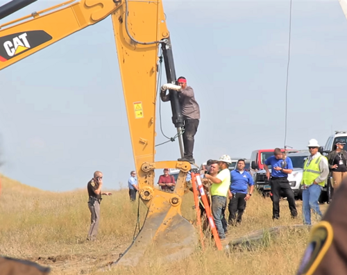 Happi American Horse, un membro della Nazione Sicangu Lakota, si incatena a un macchinario da costruzione in un atto di azione diretta contro il Dakota Access Pipeline nell'agosto 2016.