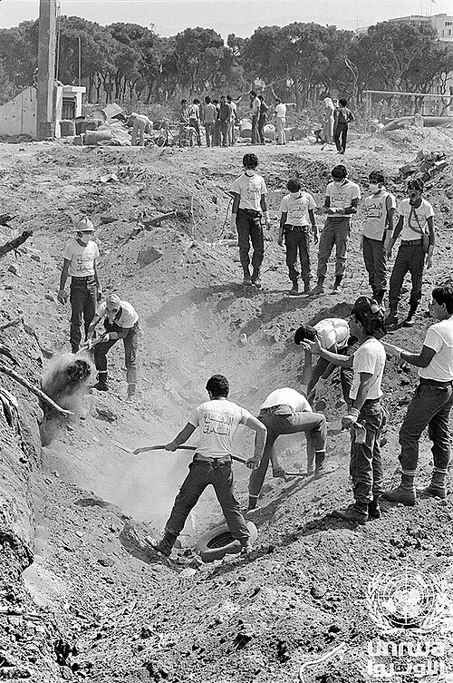 Hombres cavan una fosa común para las víctimas de la masacre. Foto del Archivo de la UNRWA.